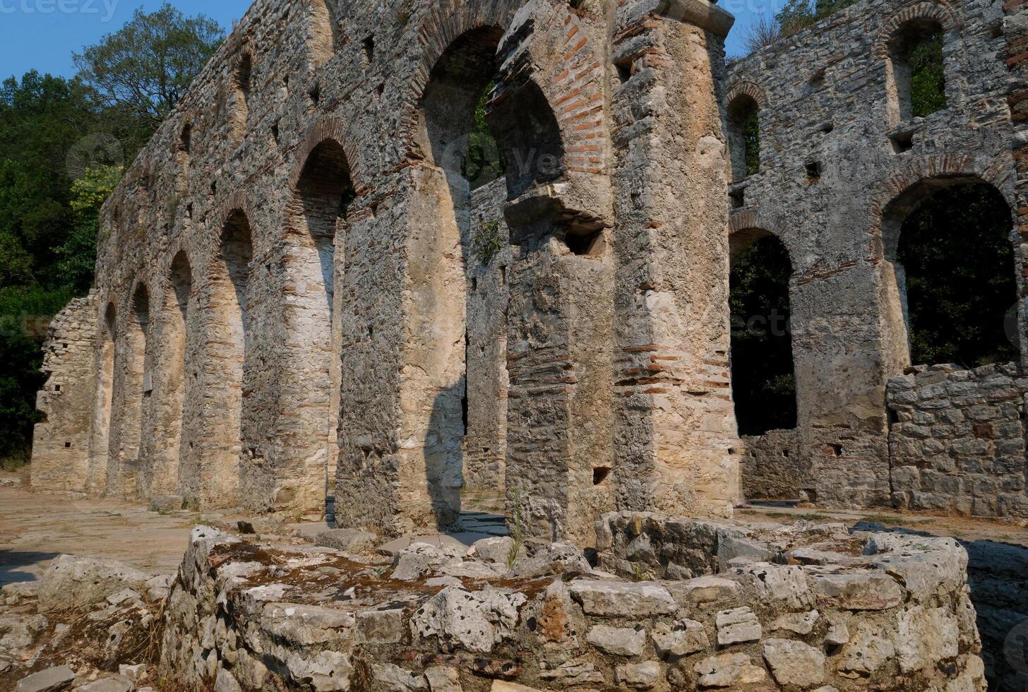 Ruins of the Great Basilica in Butrint National Park, Buthrotum, Albania. Triconch Palace at Butrint Life and death of an ancient Roman house Historical medieval Venetian Tower surrounded photo
