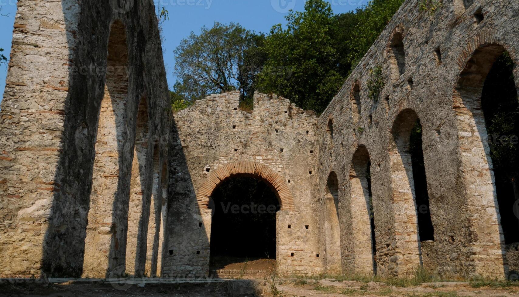 Ruins of the Great Basilica in Butrint National Park, Buthrotum, Albania. Triconch Palace at Butrint Life and death of an ancient Roman house Historical medieval Venetian Tower surrounded photo
