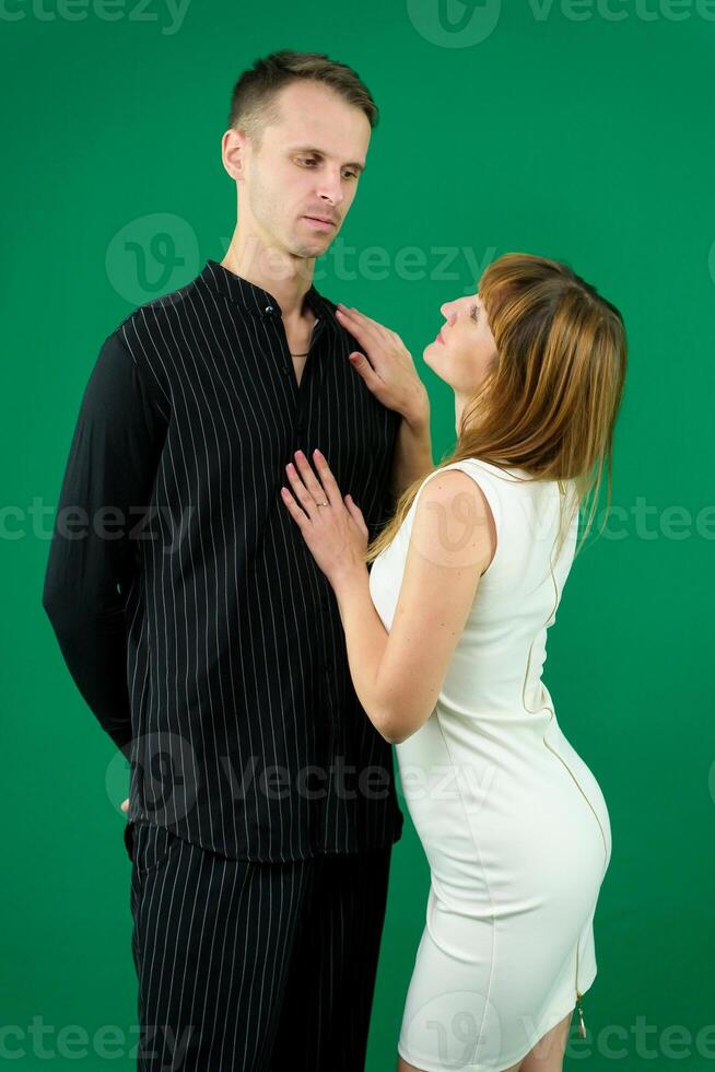 Beg squat look into the eyes stretch hands there desire to dance girl invites a man to dance on a green background makes eyes denim clothes chromakey bring time with me love relationship flirting photo
