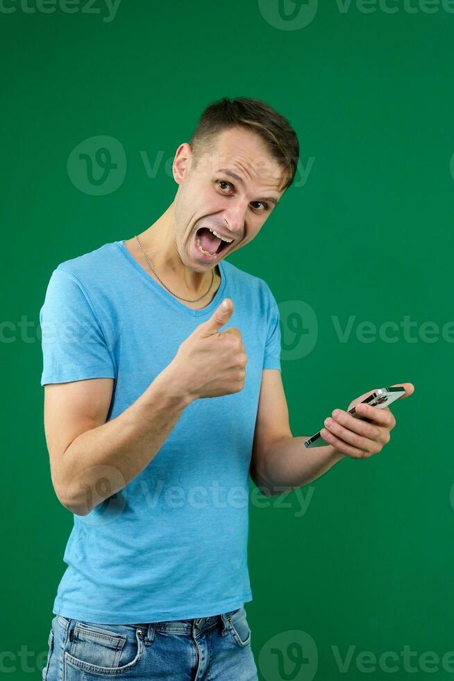 Young promoter man wear shirt white t-shirt point index finger camera on you indicate index finger aside on workspace area copy space mock up isolated on plain pastel green background studio photo