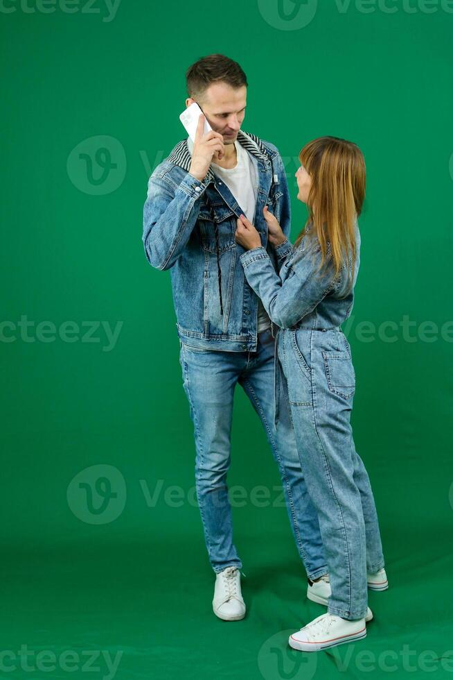 Beg squat look into the eyes stretch hands there desire to dance girl invites a man to dance on a green background makes eyes denim clothes chromakey bring time with me love relationship flirting photo