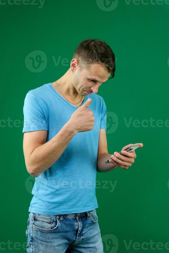Young promoter man wear shirt white t-shirt point index finger camera on you indicate index finger aside on workspace area copy space mock up isolated on plain pastel green background studio photo