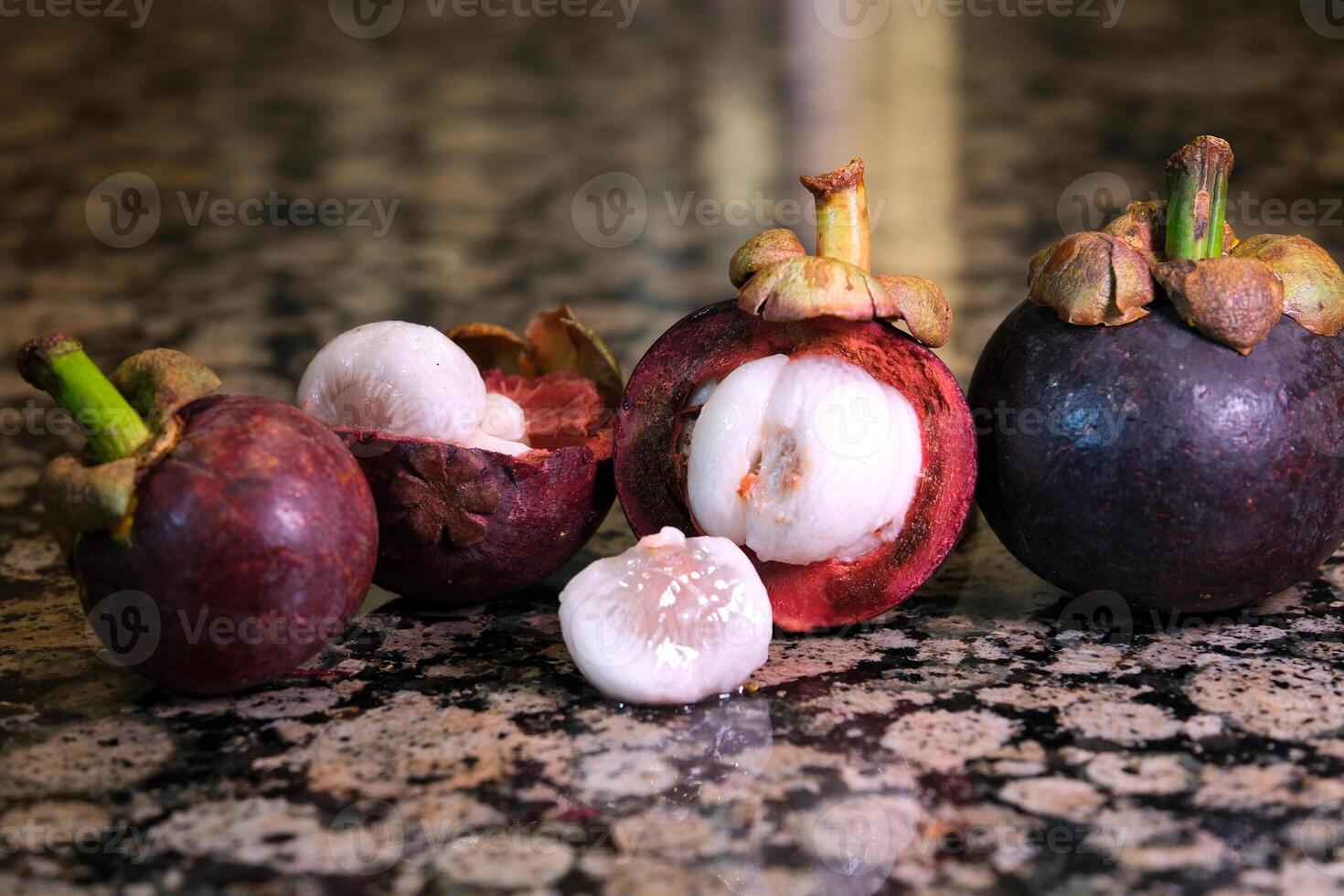Mangosteen Ready to eatfruit of Thailand, selective focus asian thai mangosteen fruit stands on a marble table in a section a few pieces black background tropical fruit looks like a parsley photo