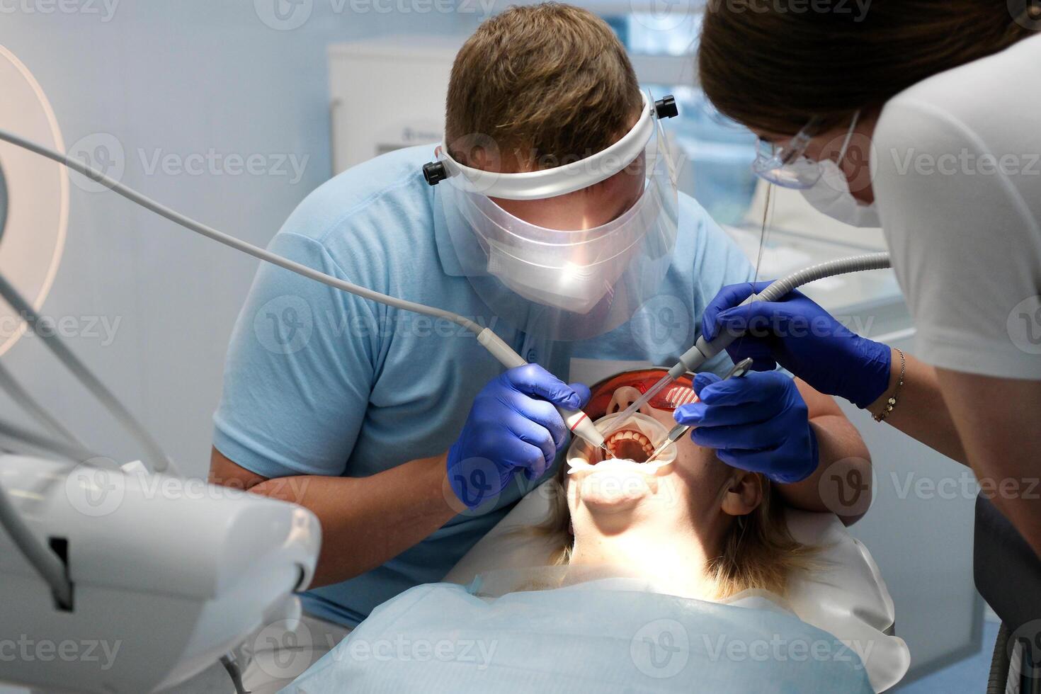 Doctor scans the patient's teeth in the clinic. The dentist holds in his hand a manual 3D scanner for the jaw and mouth. Dental health. Creates a 3D model of teeth and gums on a medical monitor. photo