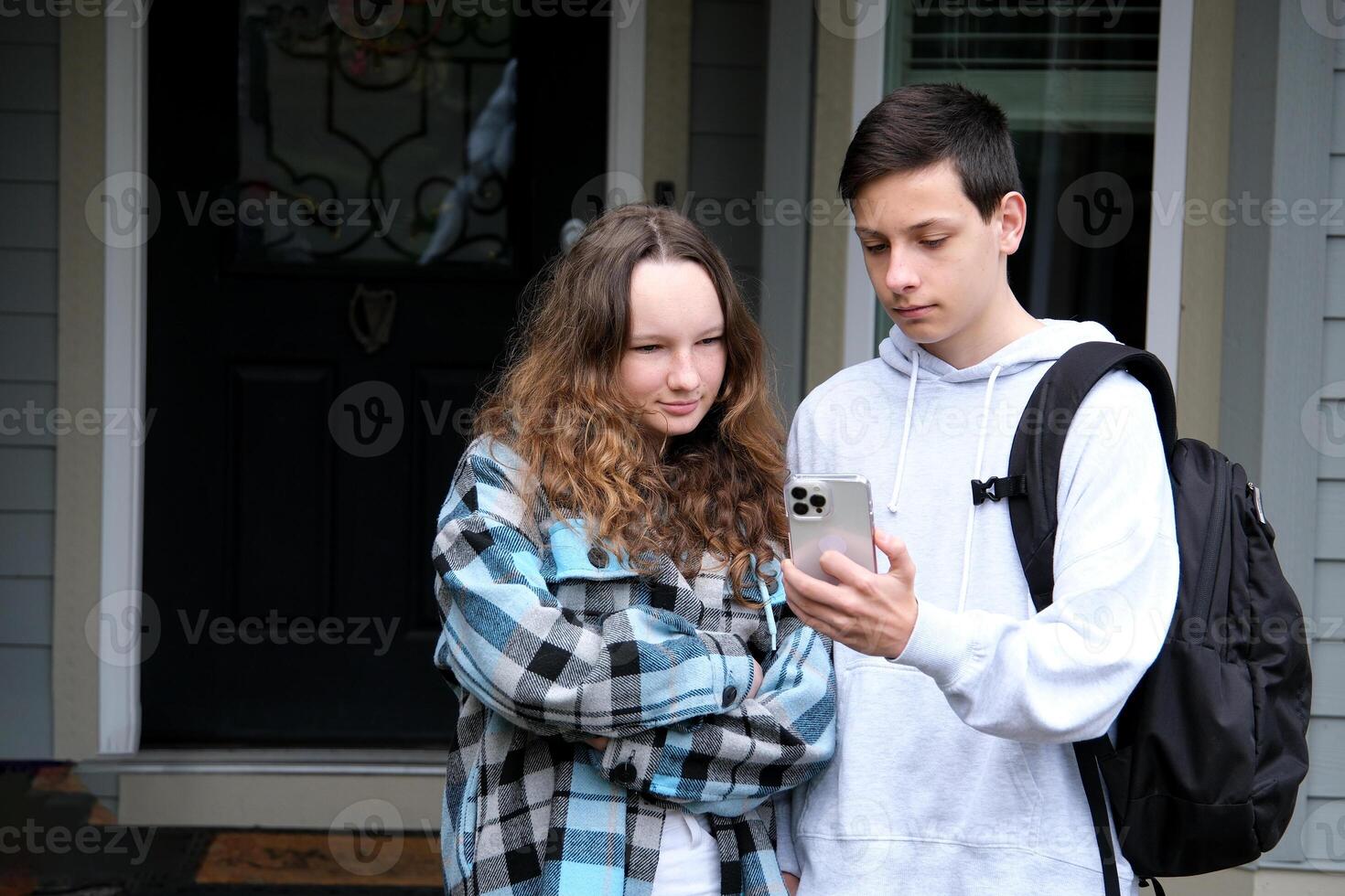 A boy and girl student are sitting in a hallway on stairs talking for a youth communication concept. photo