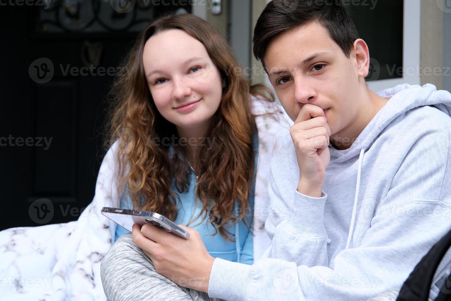 give a phone number to take a girl home from university school, a guy and a woman, a girl, phone in hands, order delivery, look at a new gadget app on the phone, look into each other's eyes, be shy photo