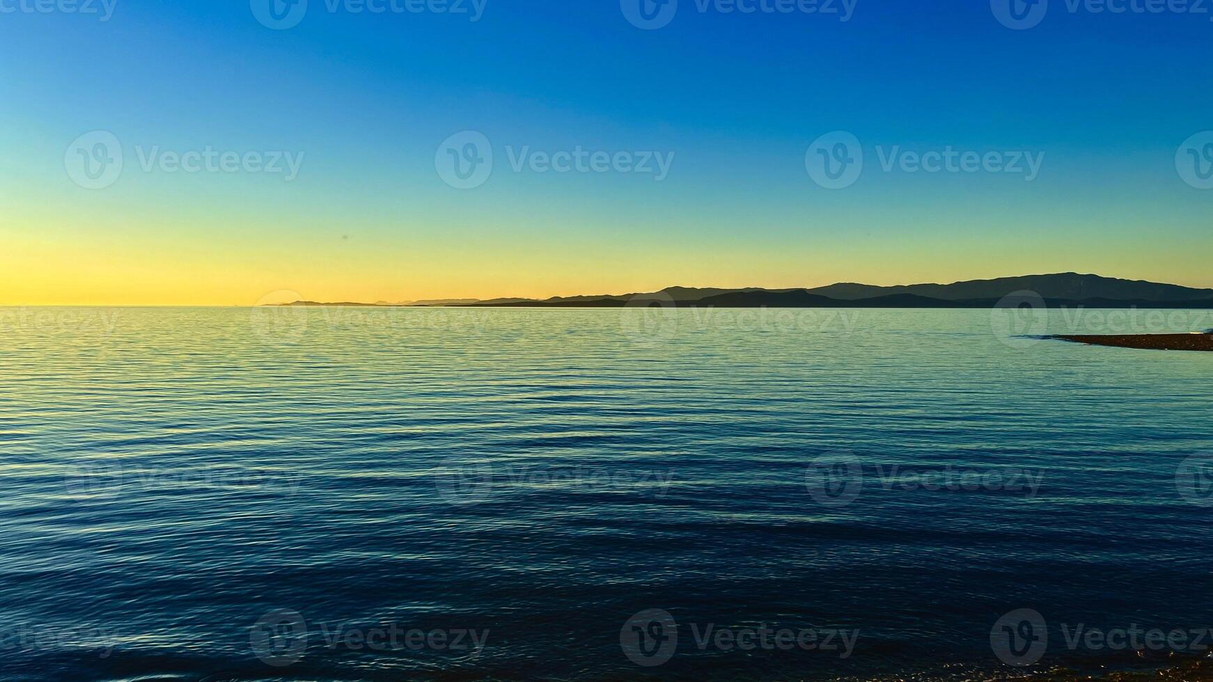sunset on the Ocean Calmness calm sea on Vancouver Island resting in trailers on the shore bright colors of dark blue orange stripe on the horizon from the sun rich space for text travel advertising photo
