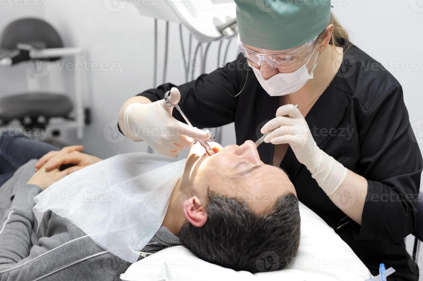dentistry office tools woman doctor injects anesthesia with carpool syringe to patient dental operation photo