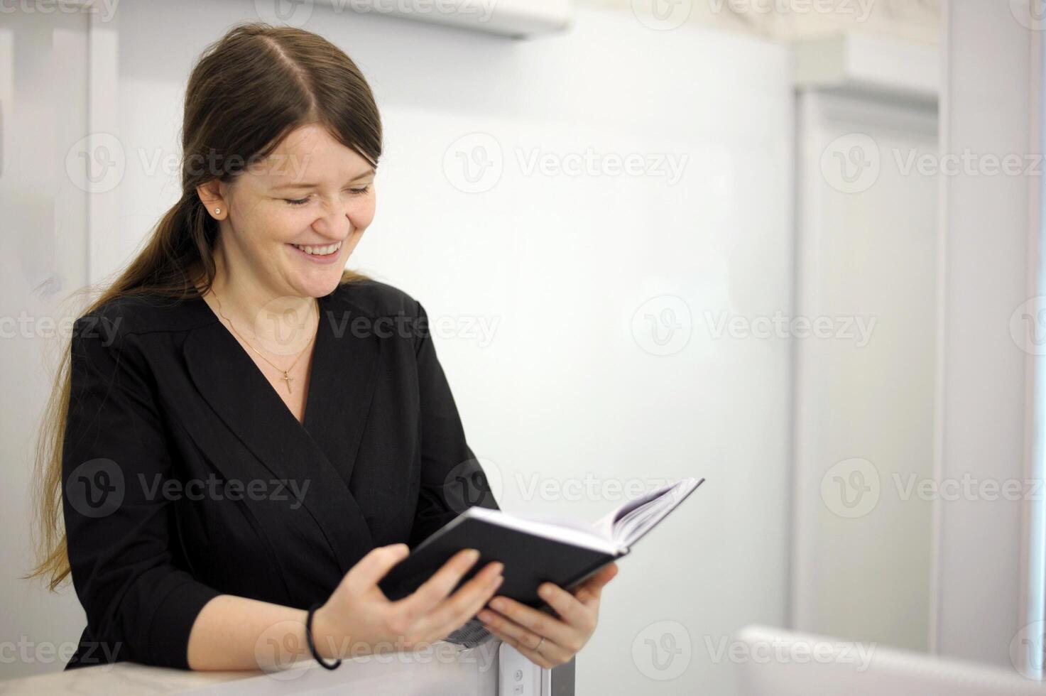 hands of a black notebook with notes notes an interesting book young woman sits at a computer at the reception of a white light office hospital dentistry any computer programmers photo