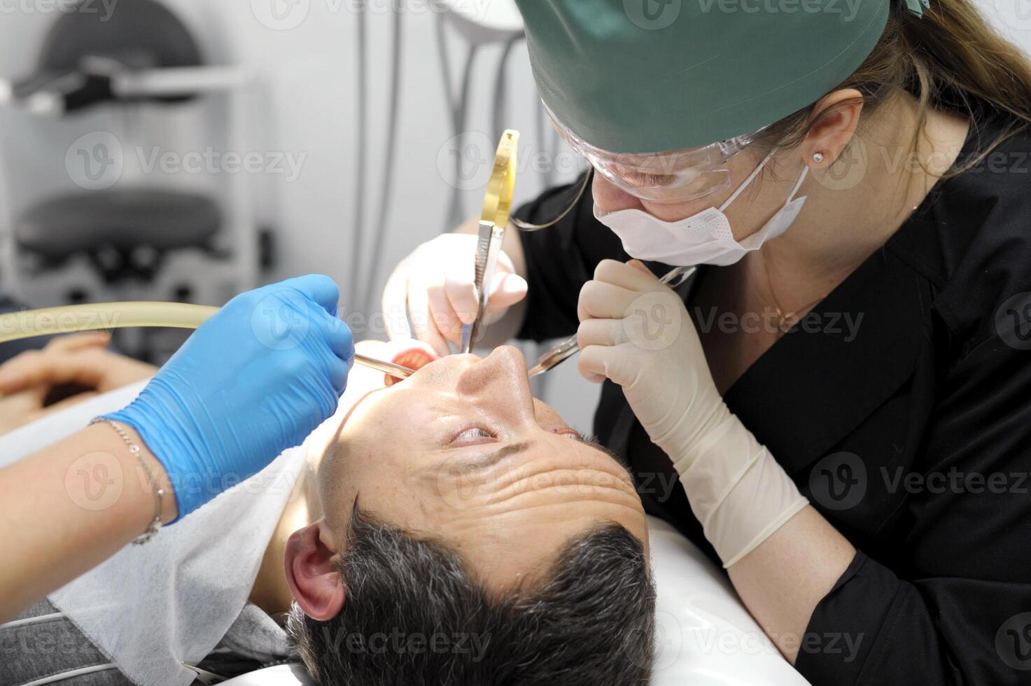 pull a tooth out adult man praying with his eyes looks at the doctor who tears his tooth dentistry hurts the request of a man woman photo