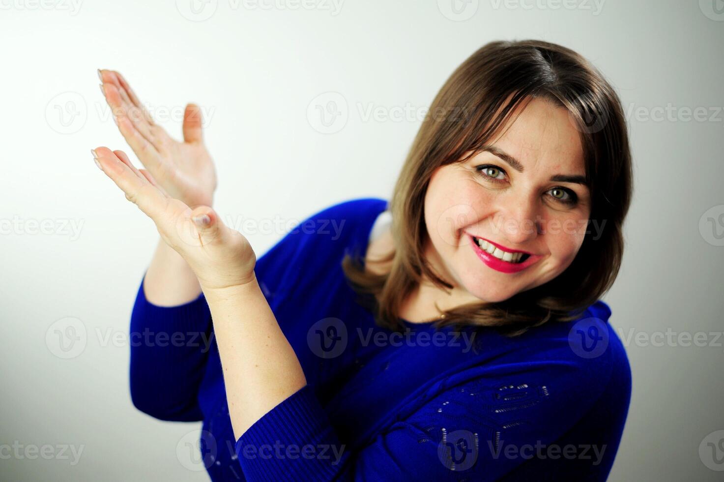 sincere laugh beautiful white teeth long hair Insanely beautiful girl advertises something on white background points to the side with her fingers, then shows her thumb into the frame photo