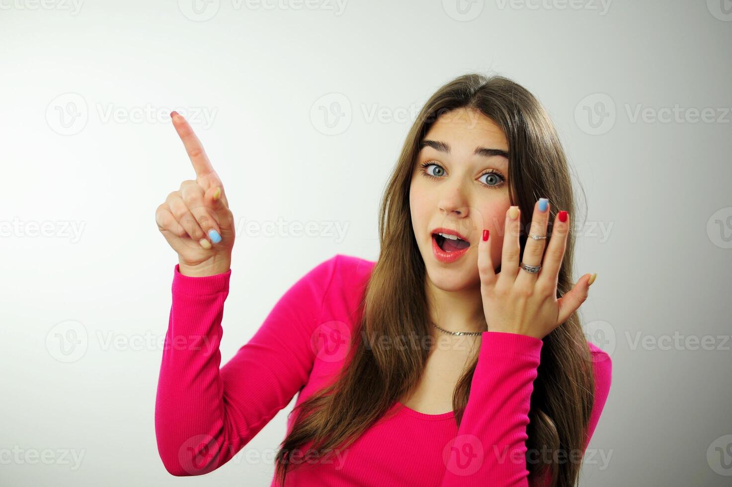 sincere laugh beautiful white teeth long hair Insanely beautiful girl advertises something on white background, she turns and points to the side with her fingers, then shows her thumb into the frame photo