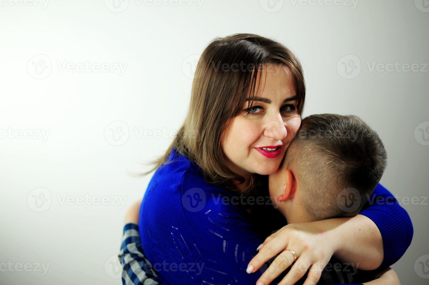 people tenderness relationship emotions Sad child hugging his mother Mom in a blue package tenderly hugs the prices who returned it under her arm and leaned very gently hugs love family comfort photo