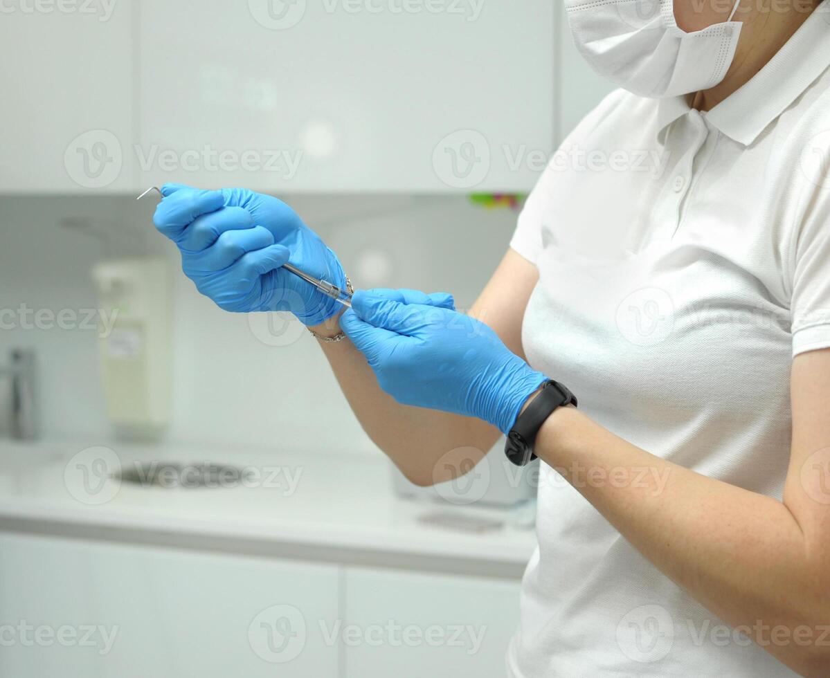 carpule probe carpulse syringe Female doctor hands blue gloves special instruments used in dentistry for local anesthesia simple design of a cylindrical body and piston syringe, disposable photo