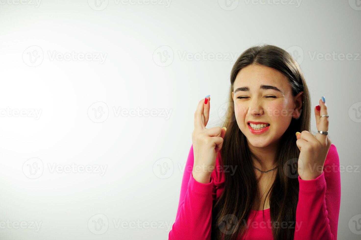 The girl crossed two fingers near her head and is very worried that everything will work out sincere smile beautiful teeth fresh good She has emotionally positive emotions long live natural hair pink photo