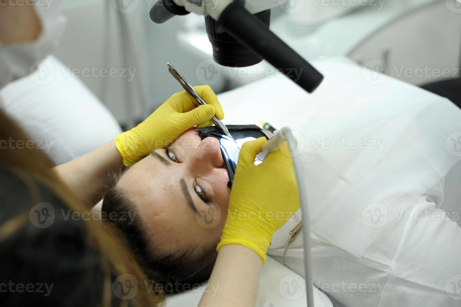 Charming young female person demonstrating her smile while being at dental examination photo