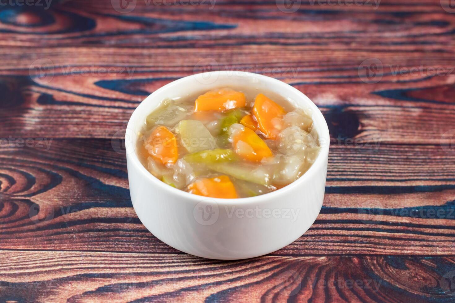 chinese mixed vegetables with capsicum, tomato, carrot, and radish served in bowl isolated on wooden background side view of bangladeshi food photo