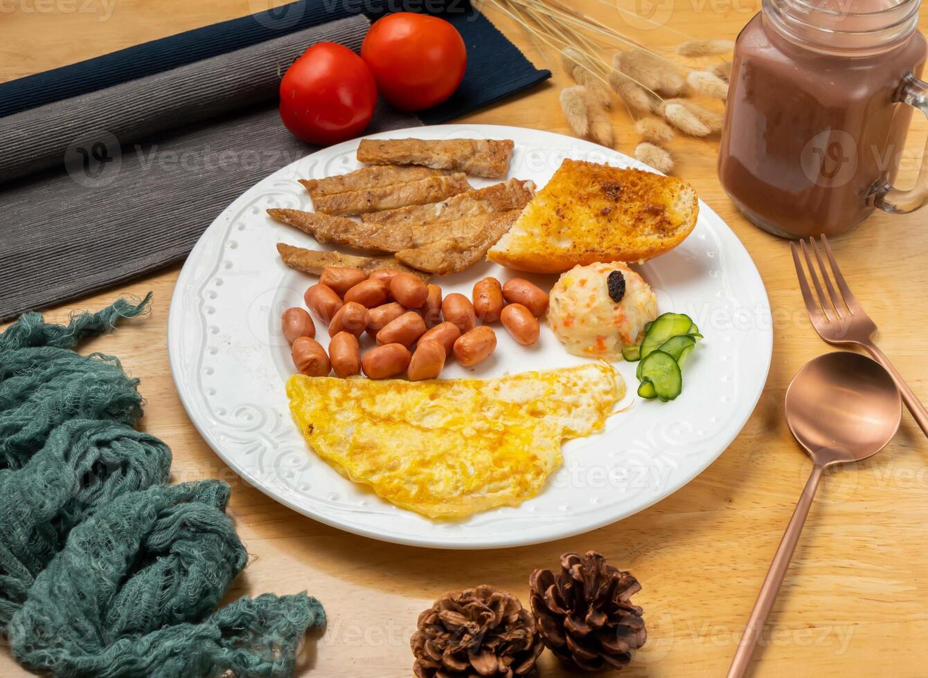 Pan fried pork chop set with omelette, beans, bread, cherry tomato, spoon and fork served in dish isolated on wooden table side view of taiwan food photo