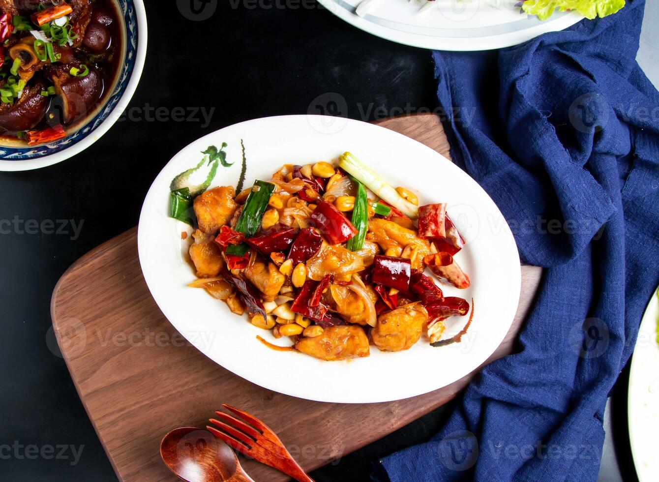 Kung Pao Chicken with spoon and fork served in dish isolated on wooden board top view of taiwan food photo