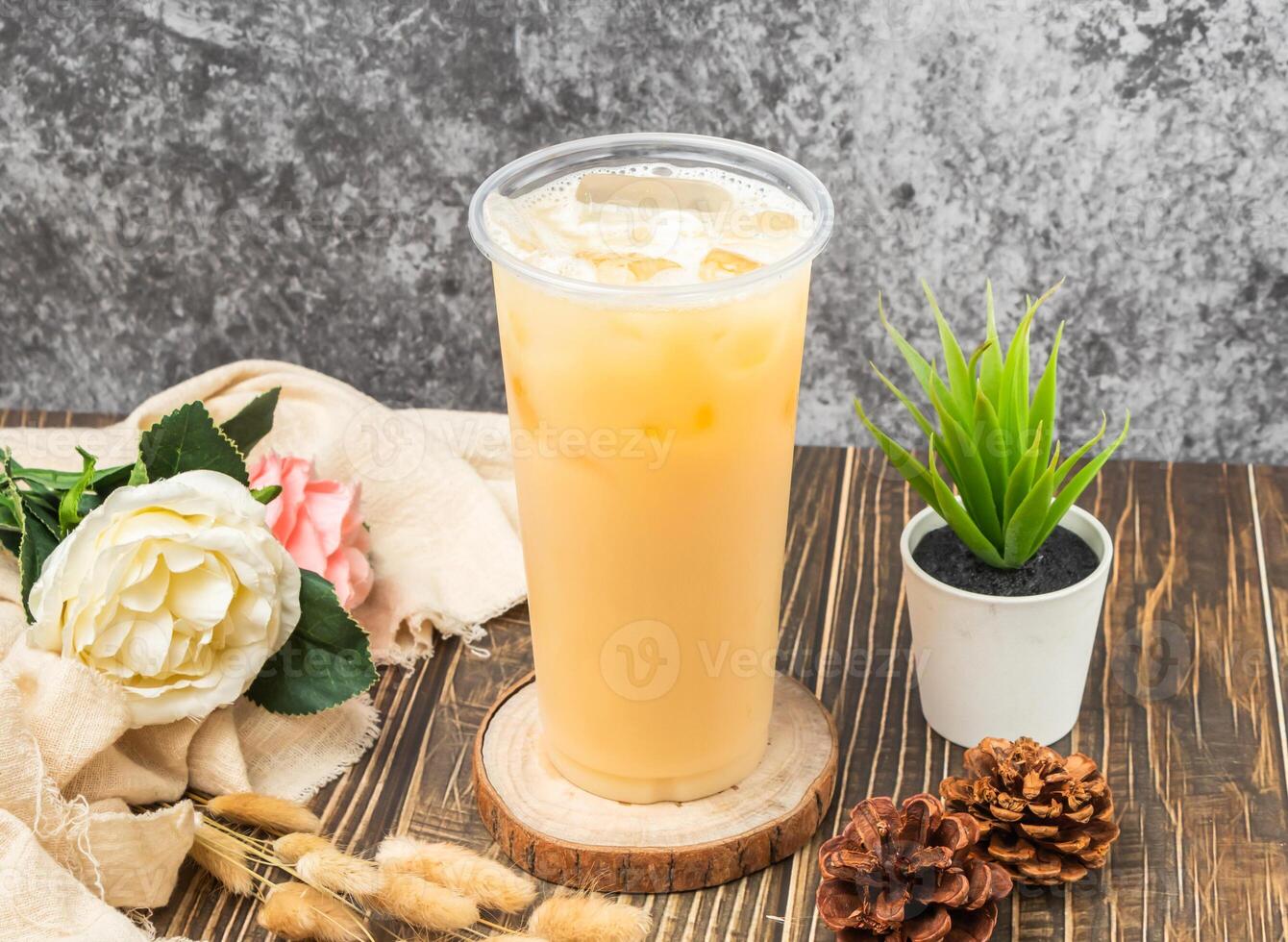 Iced Yakult Green Tea with ice cube served in disposable glass isolated n table side view of taiwanese drink photo