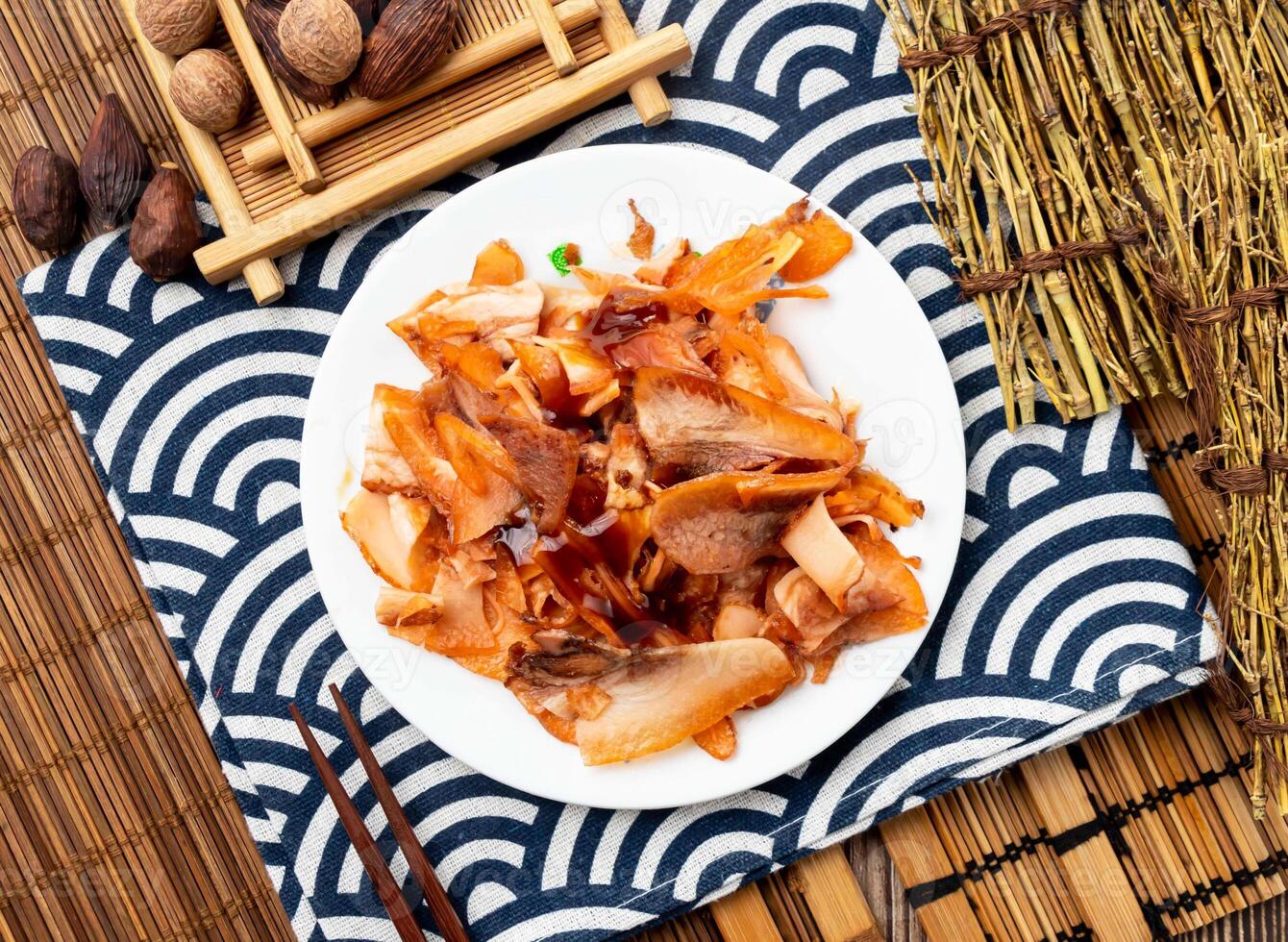 pig scalp with chopsticks served in dish isolated on napkin top view on table taiwan food photo
