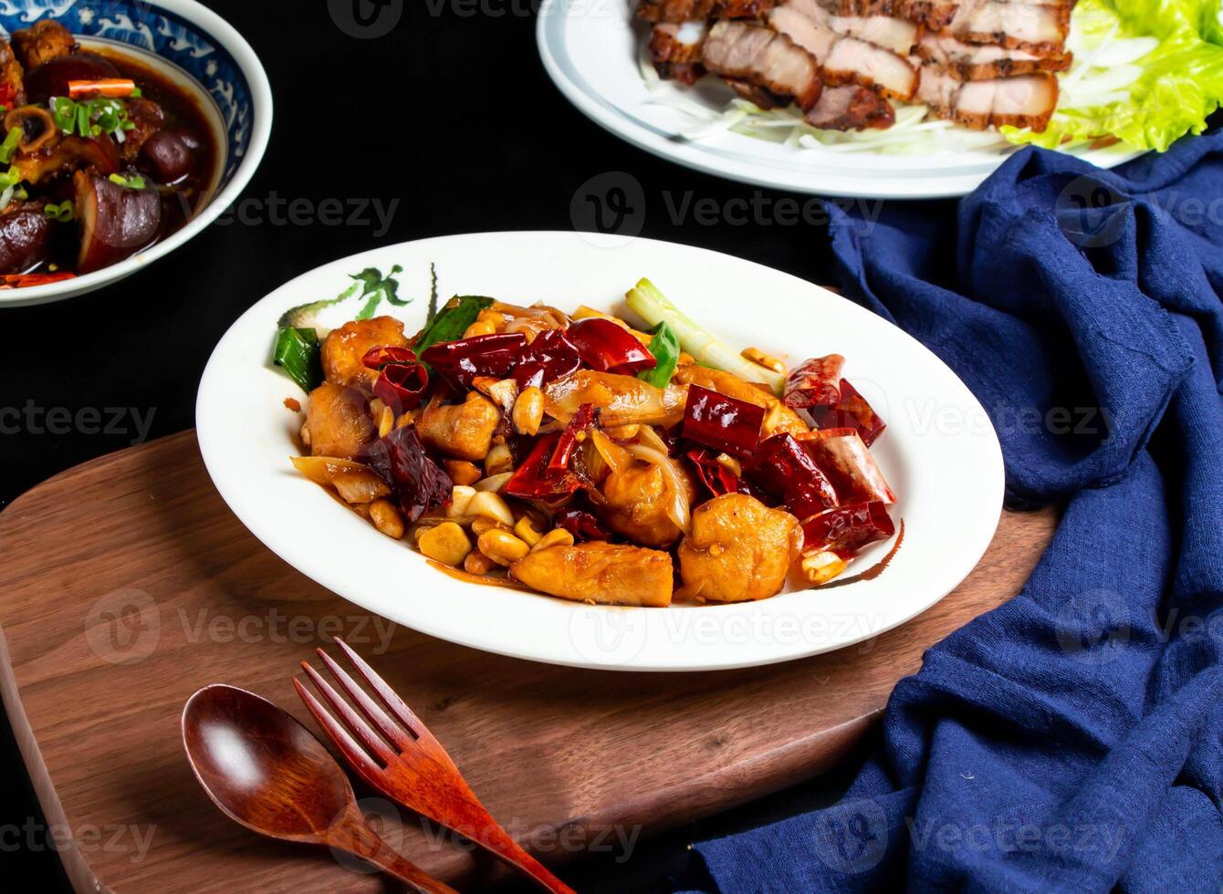 Kung Pao Chicken with spoon and fork served in dish isolated on wooden board side view of taiwan food photo