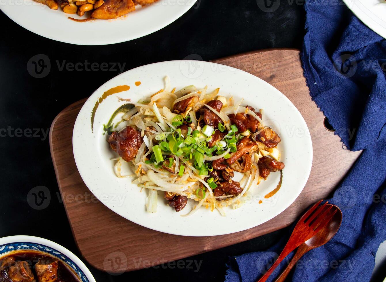 Salt and pepper intestines with spring onion, spoon and fork served in dish isolated on wooden board top view of taiwan food photo