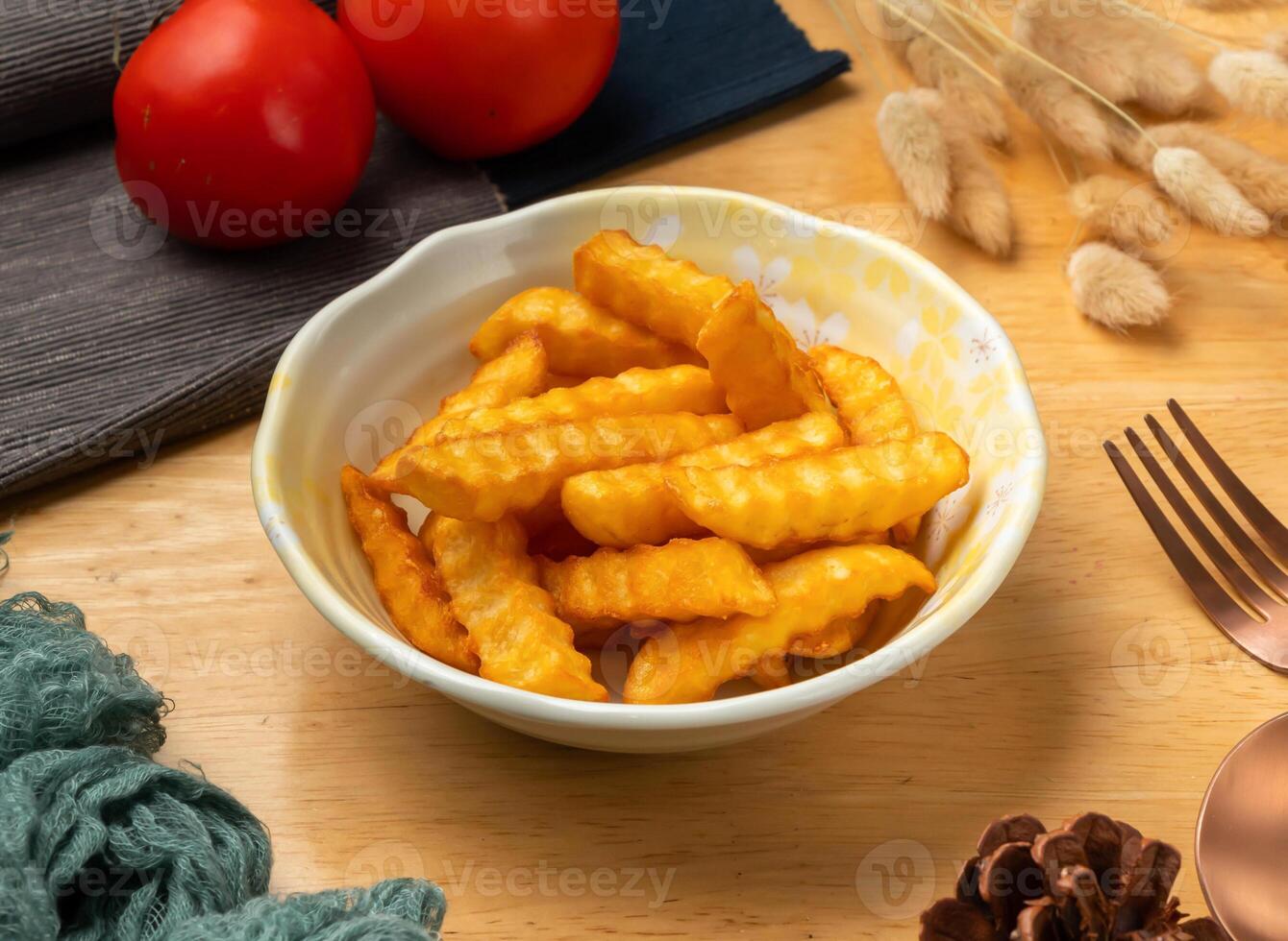 Potato Frech fries with cherry tomato, spoon and fork served in dish isolated on wooden table side view of taiwan food photo