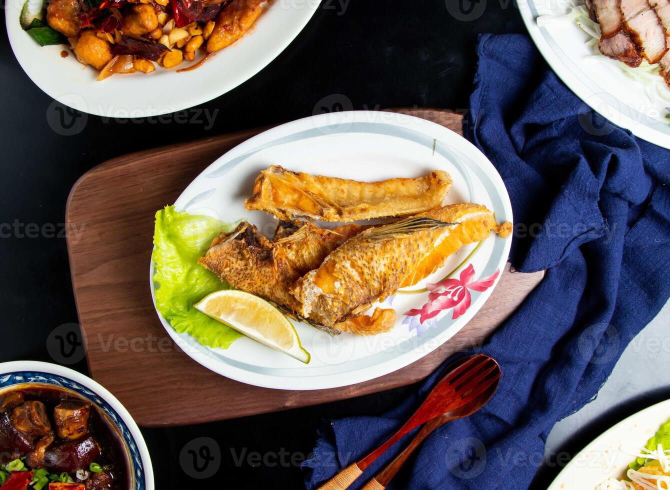 Fried Fish Jaw Roast with lemon, spoon and fork served in dish isolated on wooden board top view of taiwan food photo