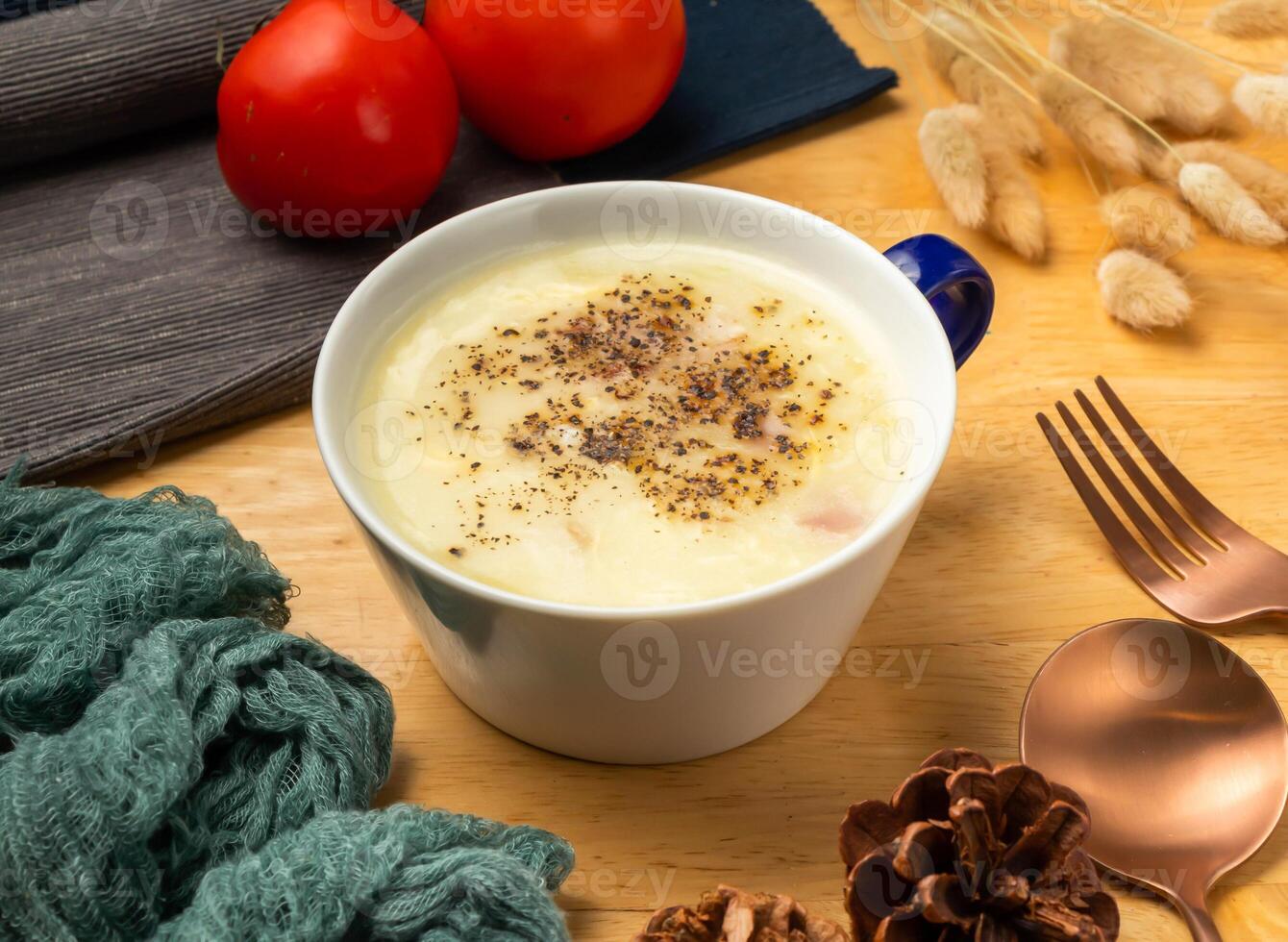 corn soup creamy with cherry tomato, spoon and fork served in cup isolated on wooden table side view of taiwan food photo