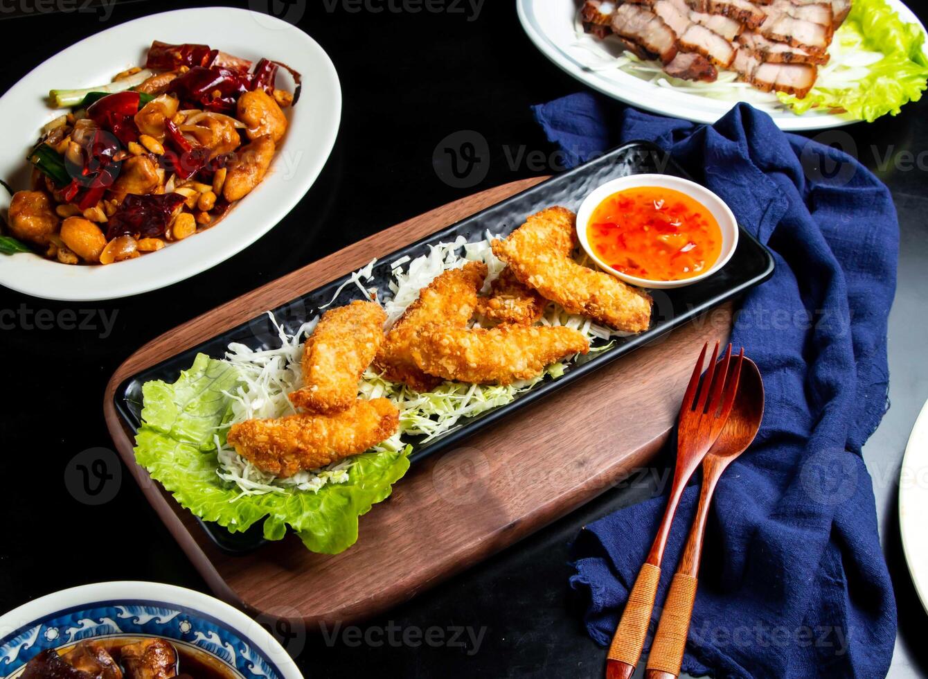Crispy fish fillet with chilli sauce spoon and fork served in dish isolated on wooden board side view of taiwan food photo