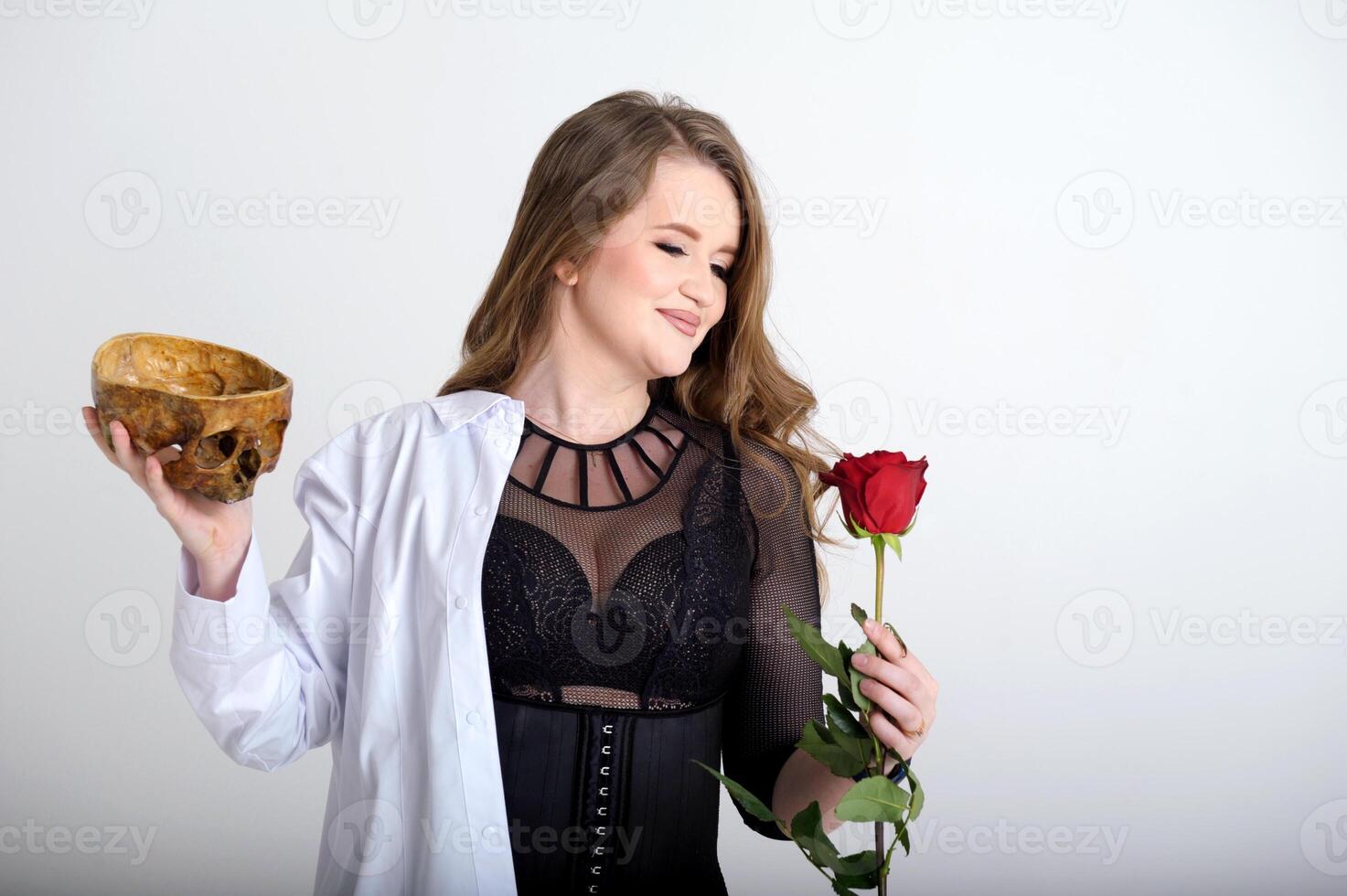 two lives in one person reincarnation of beautiful woman with red rose half of the soul second part of skull medical gown in choice of difficult looks at face gently smiles on white background photo