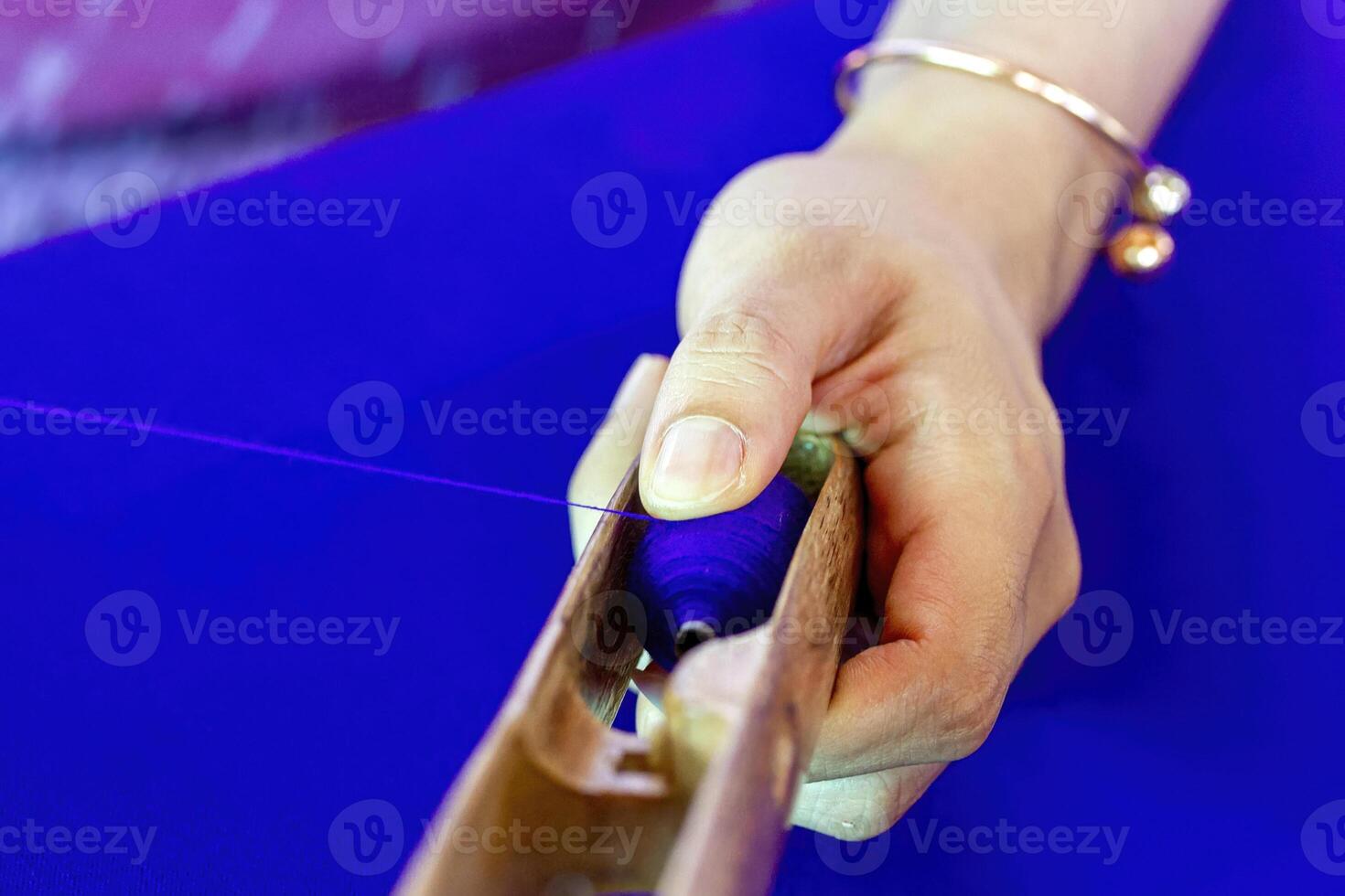 Hand spinning purple silk thread photo