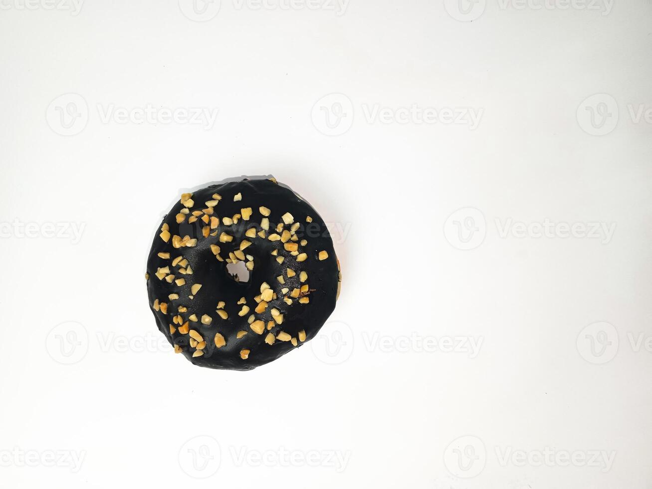 A chocolate donut with peanut chunks isolated on white background. Breakfast pastry donut. Room for text. Copy space. photo