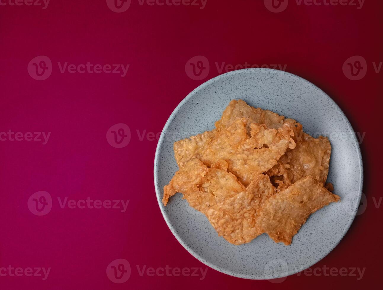 Tempe goreng. Delicious fried tempeh from Indonesia Asian culinary isolated on red background photo