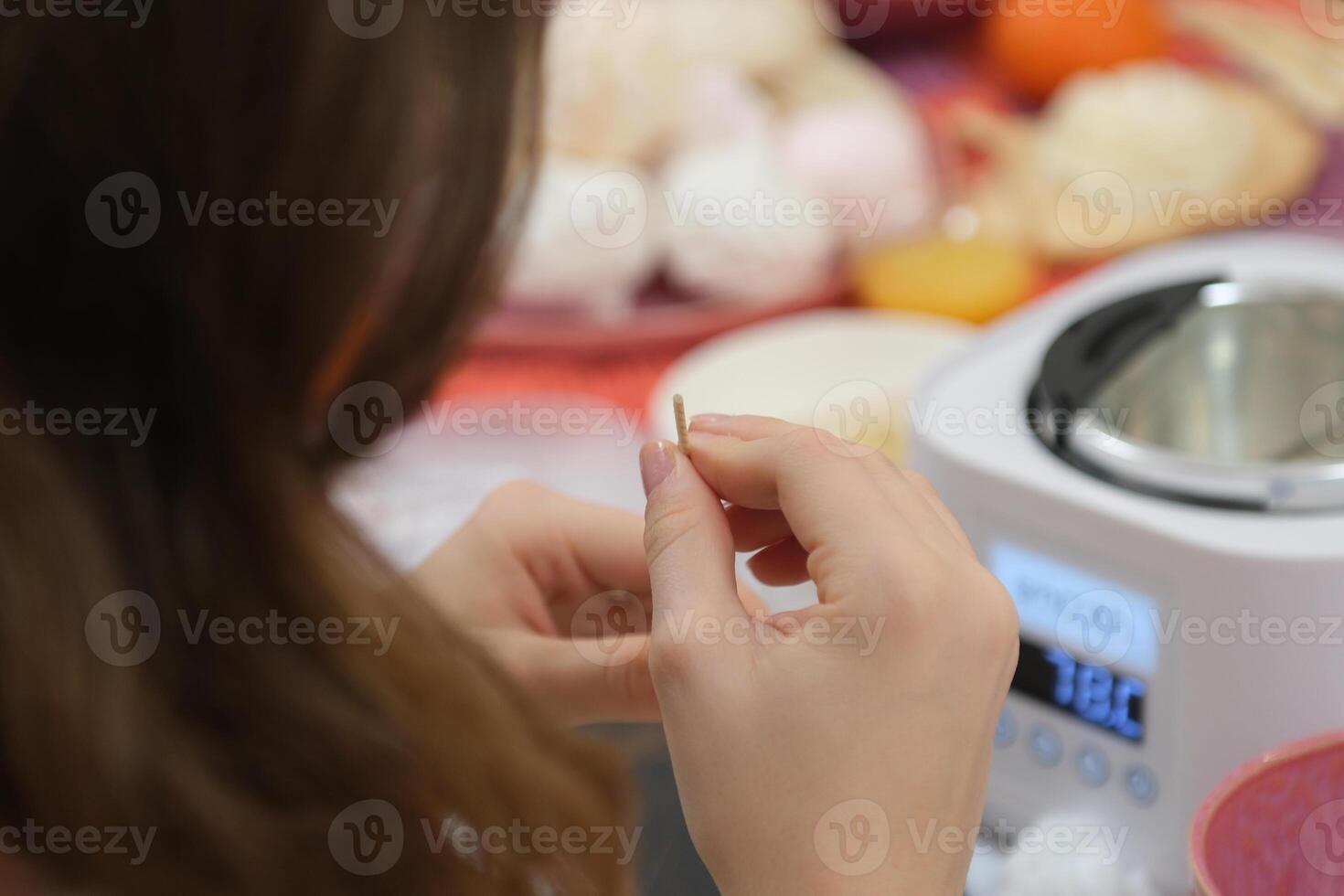 The process of making a massage candle using ingredients oils and wax measure weigh stir add close-up of women's hands. food thermometer measure wax temperature women's party women witches witchcraft photo