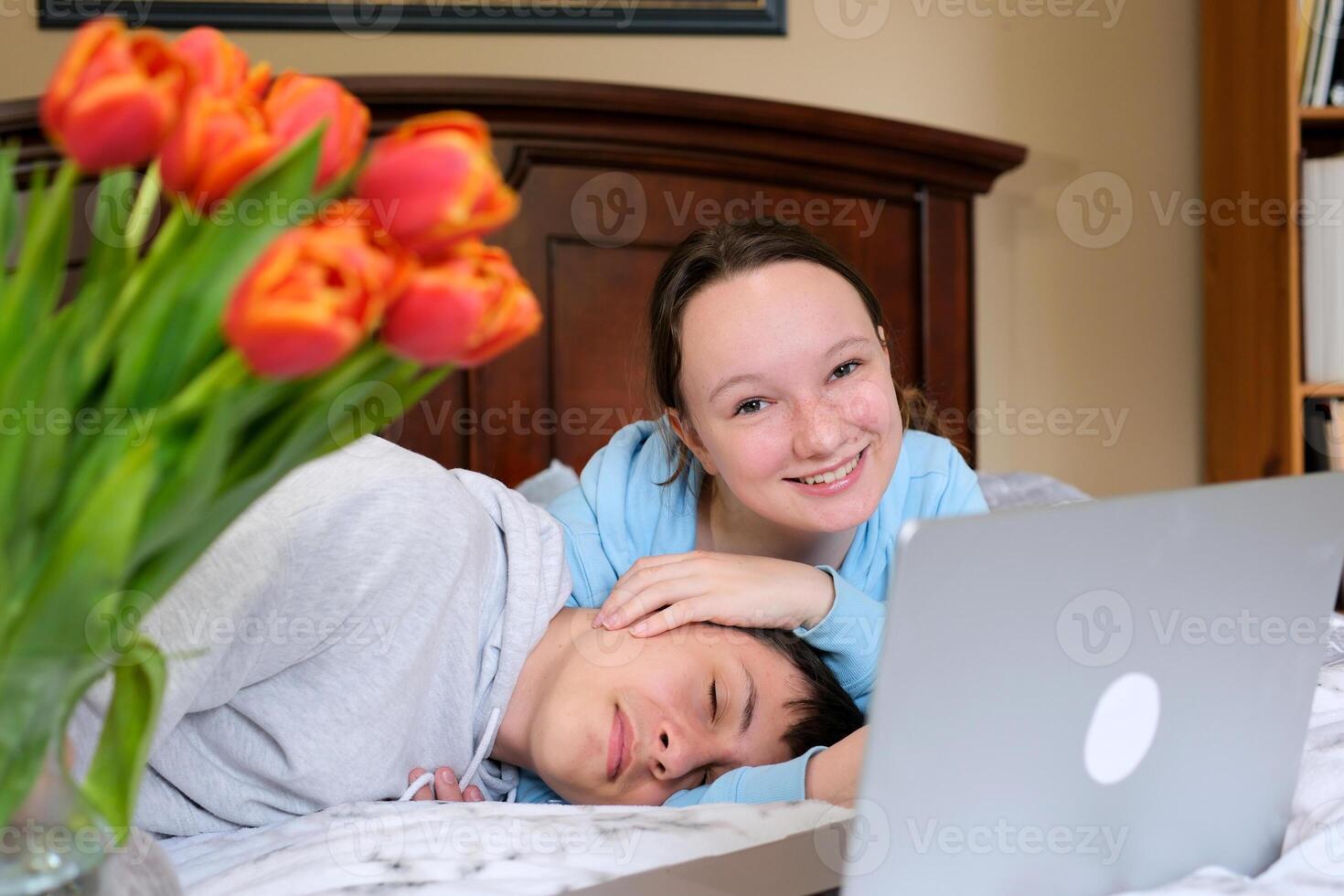 Happy Young couple sweet in love with relationship enjoying, drink a coffee and using notebook computer on the bedroom background concept. photo