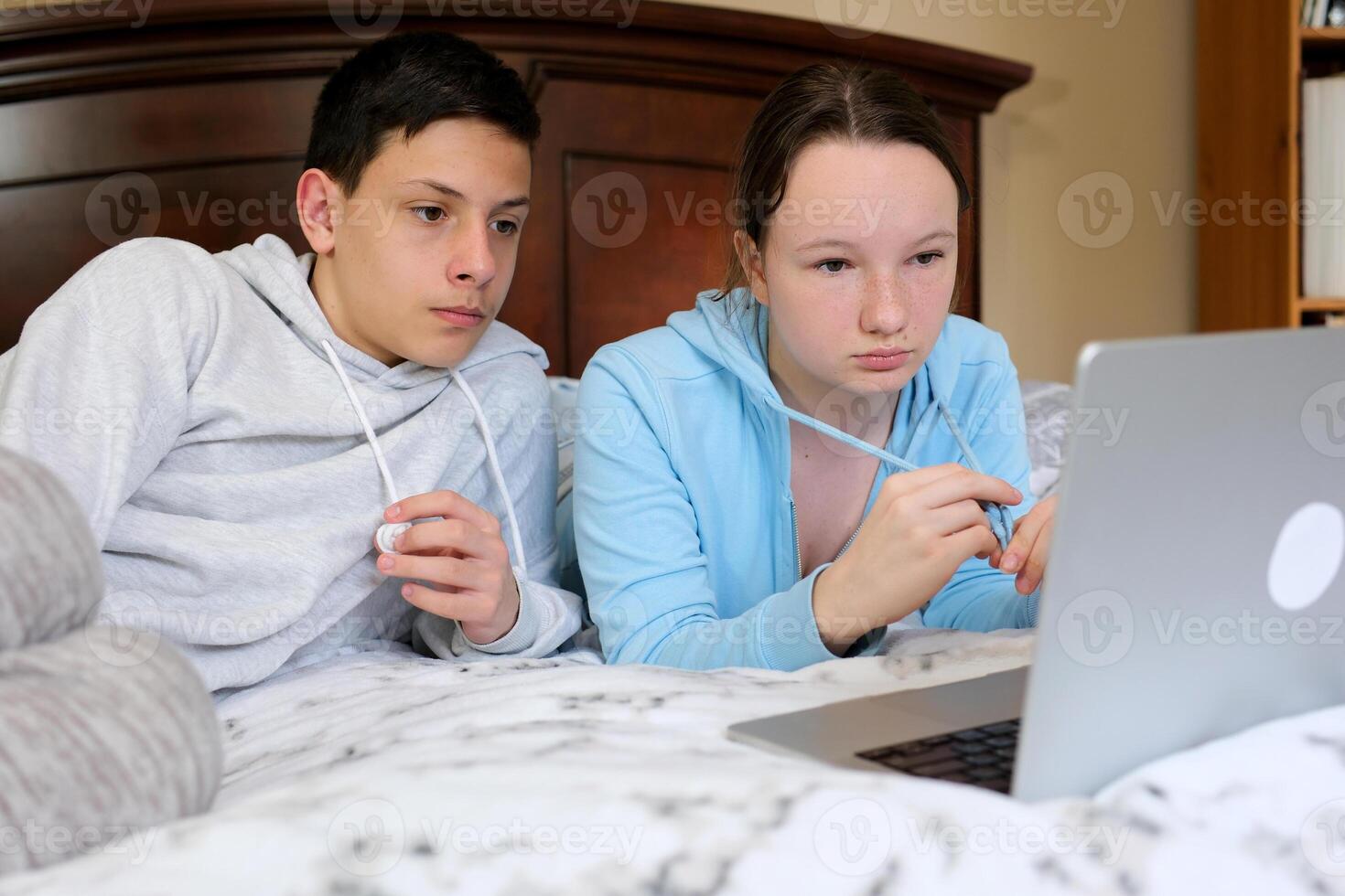 Ambitious Young Couple Working on Laptop in Bed Young couple signing documents together while sitting on the couch at home photo