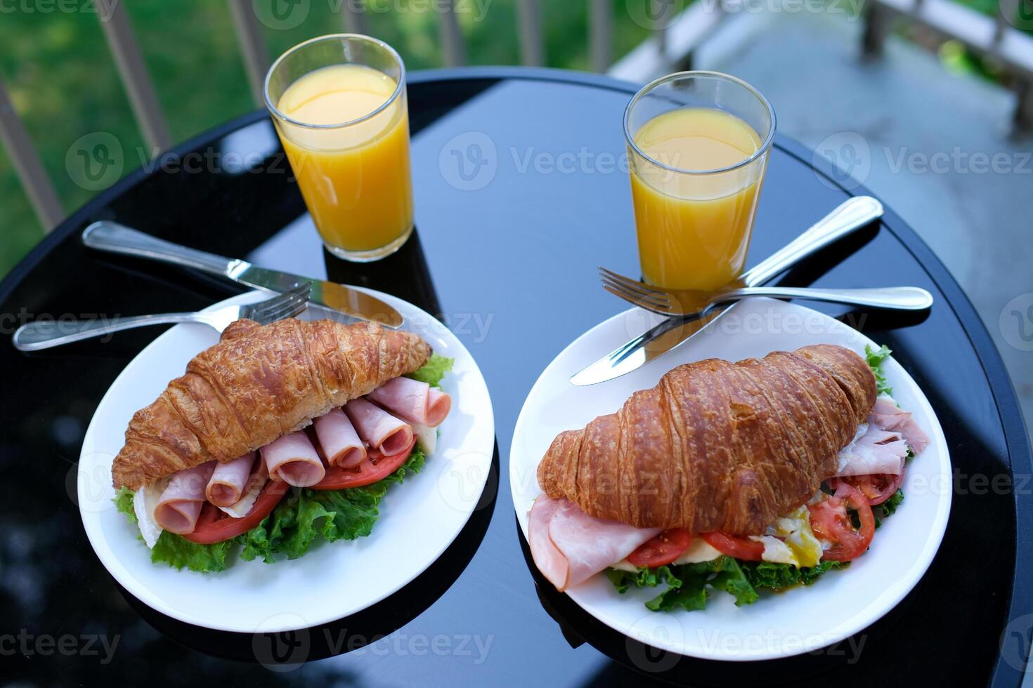 six pieces of bacon rolled into a sandwich croissant Lettuce leaves Brie cheese breakfast chic food on a black plate restaurant serving serving tomato outdoors summer photo