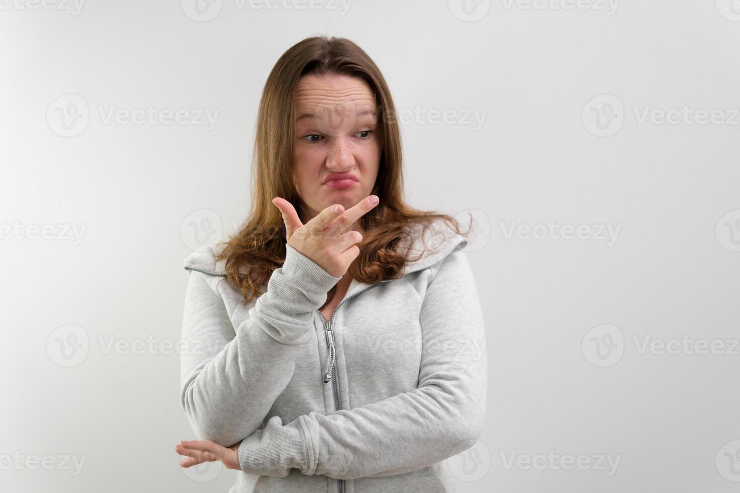 Confused woman shrugs and can not understand why she says so, confused and angry, wearing casual sportswear isolated on white background. Human reactions and perception photo