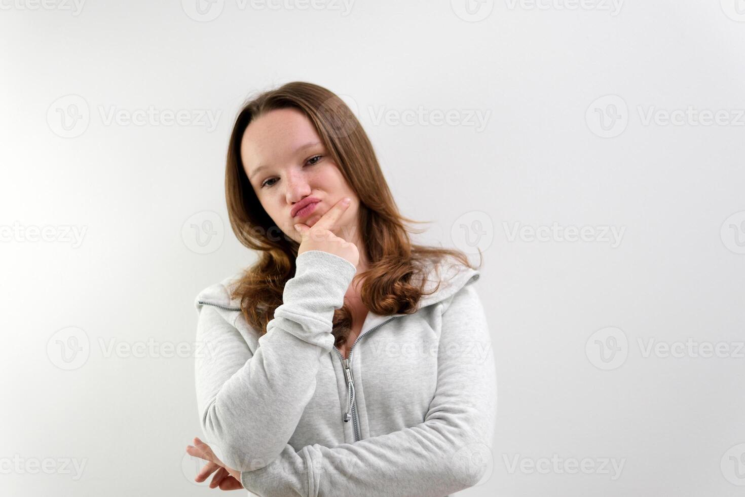 Confused woman shrugs and can not understand why she says so, confused and angry, wearing casual sportswear isolated on white background. Human reactions and perception photo