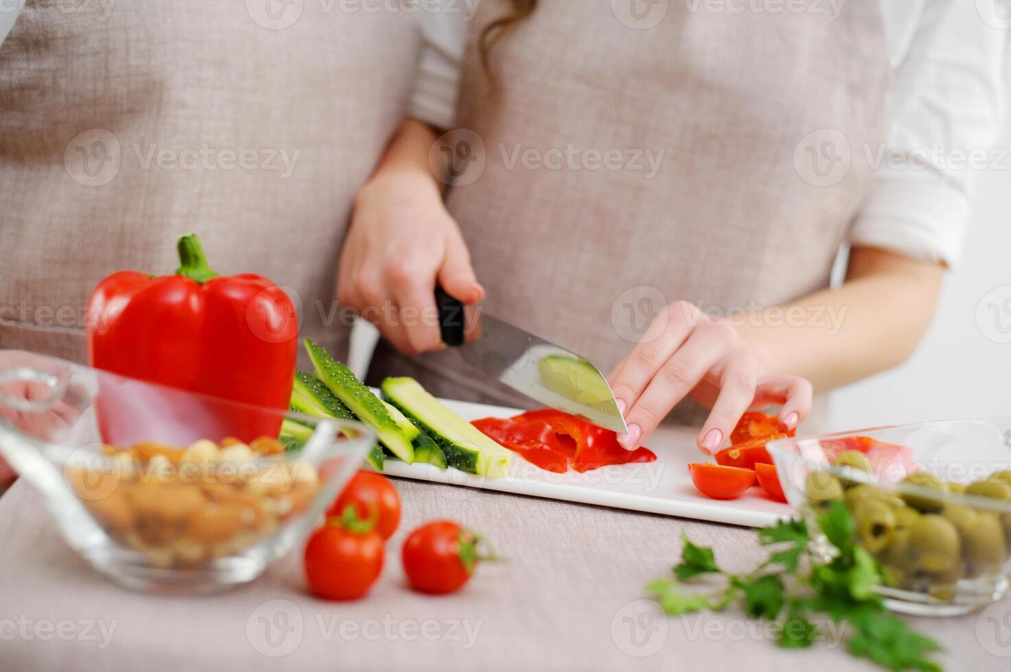 Couple preparing a meal cut bell pepper Close up cropped image of cutting board and couple cutting vegetables in the kitchen together, preparing food meal at home. Vegetarian healthy food photo