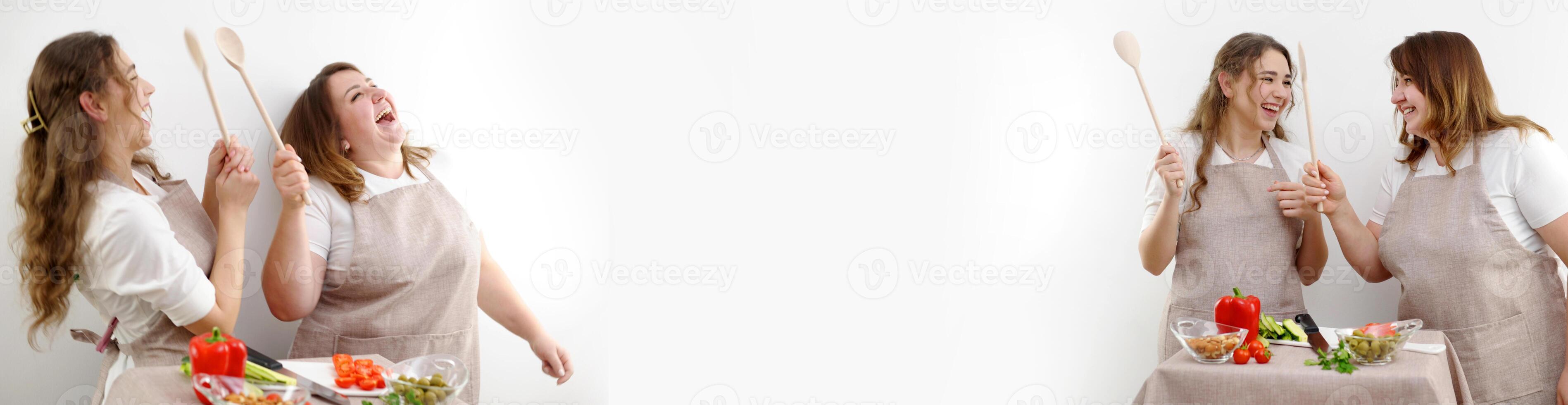 banner place for advertising text emotions of women in kitchen mother and daughter cook and apprentice two mistresses in the kitchen female prepare salad and laugh wooden spoons identical aprons photo