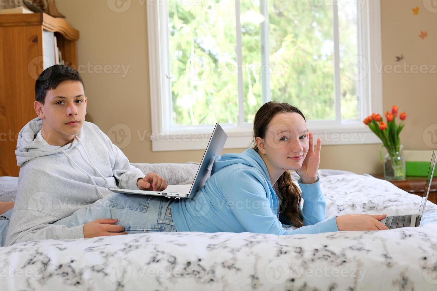 life of teenagers on laptop a boy and girl sit at table by window each with their smartphone spend time on Internet in social networks cafe School cafeteria take pictures of each other shoot videos photo
