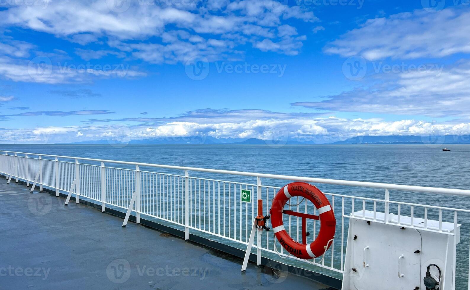 the deck of the ship is visible Only the white bridge and the red rescue circle as well as the sky The Pacific Ocean restless water on the sea Calm relax travel travel agency that will always save photo