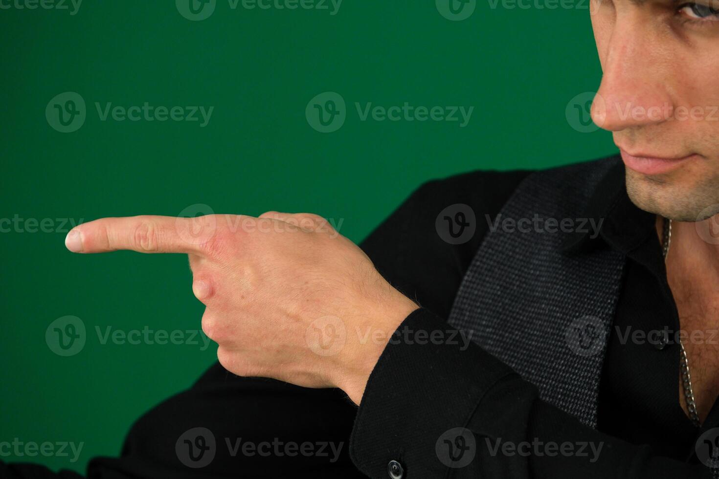 man finger show Close up portrait of young successful brunete stock-market broker guy he is smiling, wearing suit with tie and is pointing on a copyspace with his finger photo
