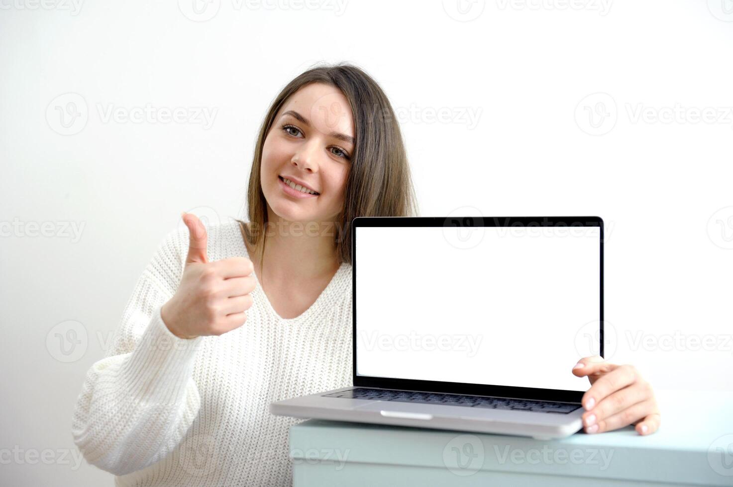 Woman with laptop showing thumbs up photo