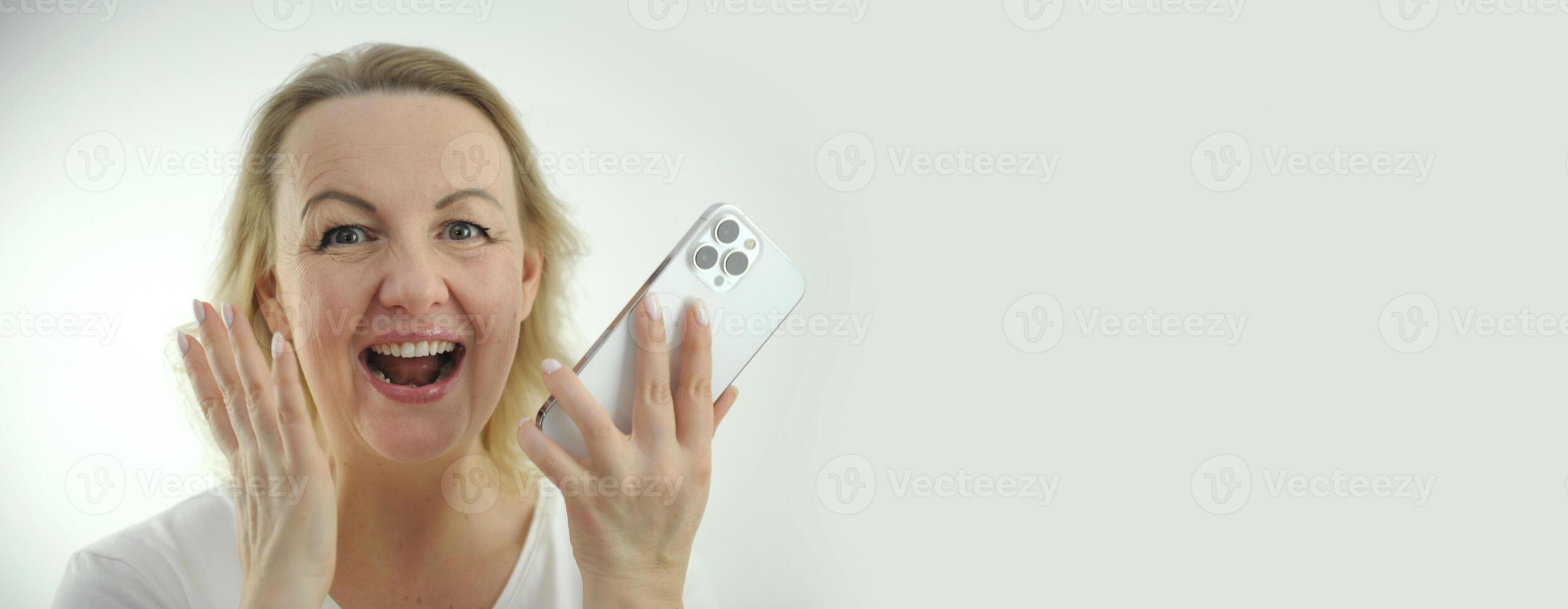 Woman looking into the frame laughing Cheerful Lady Using Smartphone banner billboard Happy African American Lady Texting On Cellphone While Standing Over White Studio Background, Copy Space photo