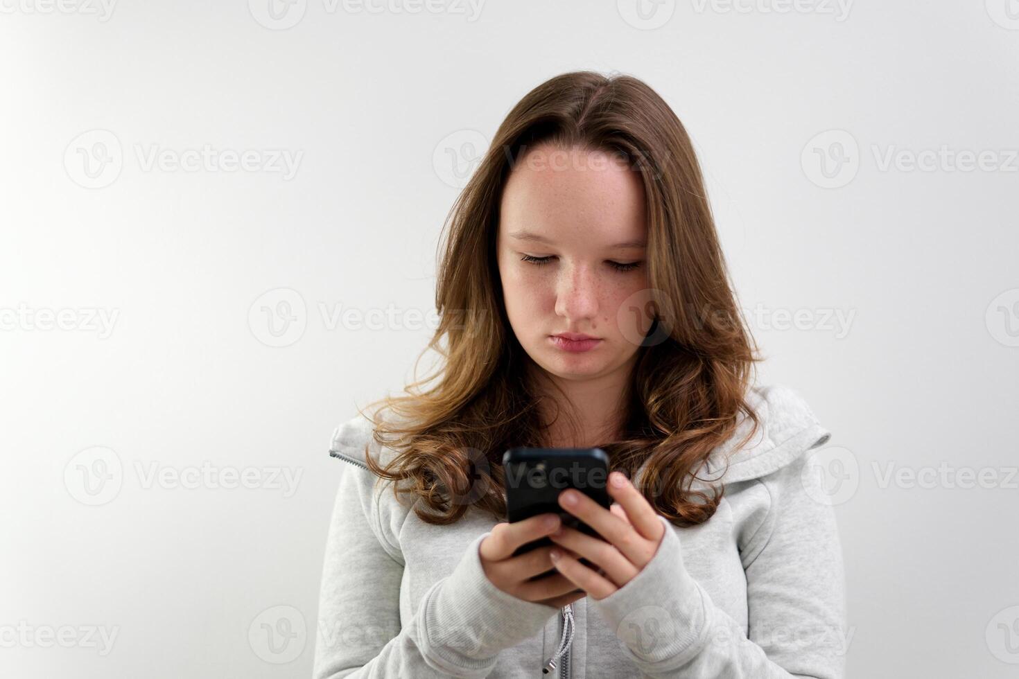 games on the phone a young girl is busy typing text or writing an SMS using the Internet wi-fi beautiful people teenager adolescence communicating with friends social networks being busy with gadgets photo