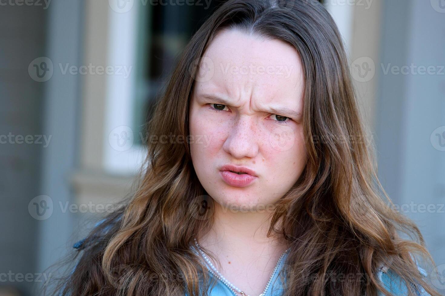 shot of dissatisfied girlfriend frowns face, raises eyebrows in bewilderment, reacts on something bad, wears casual sweater and jeans, models against pink background. Facial expressions photo